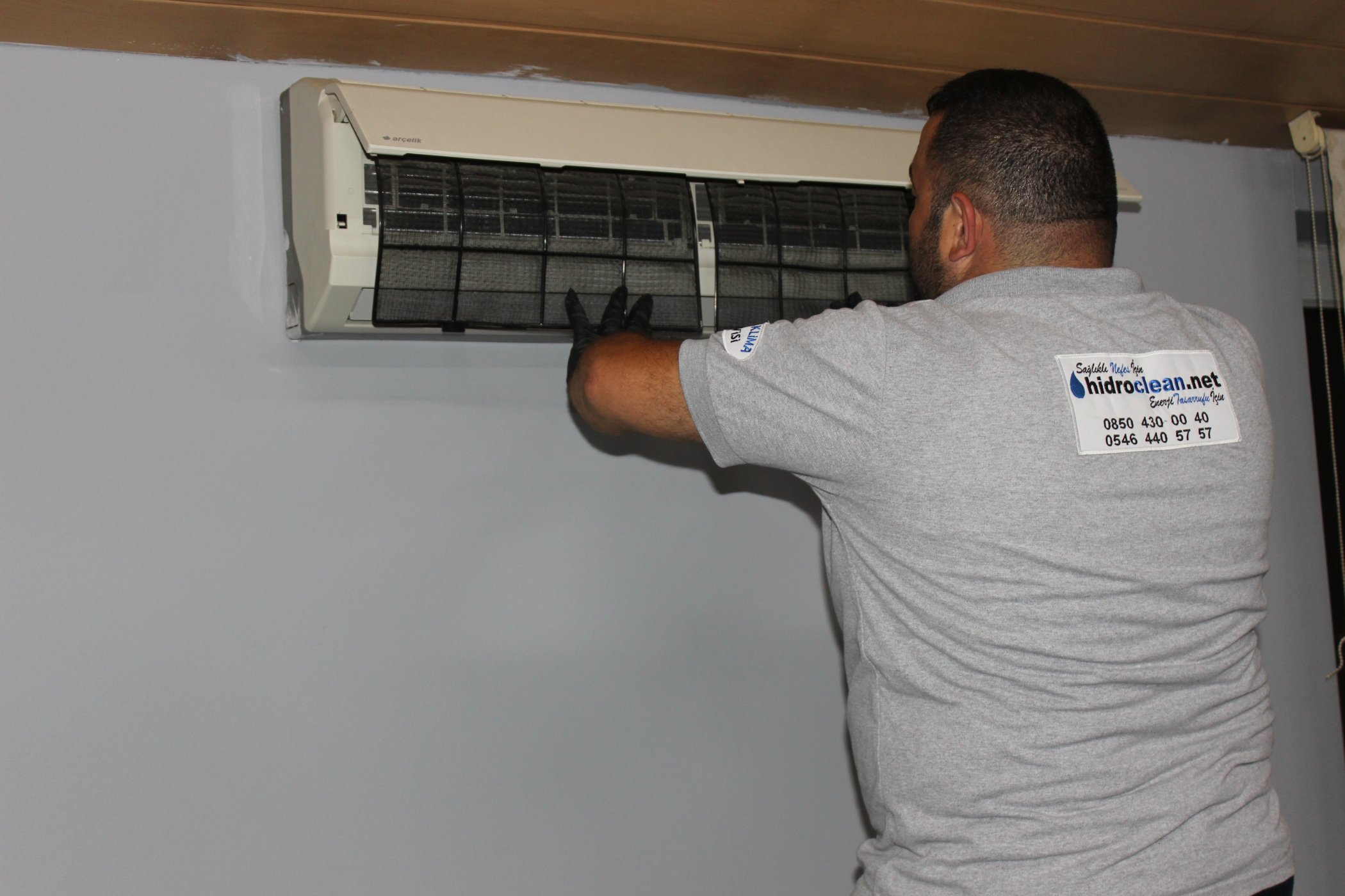Hidro Clean teknisyeni split klimanın iç ünitesinde çalışıyor